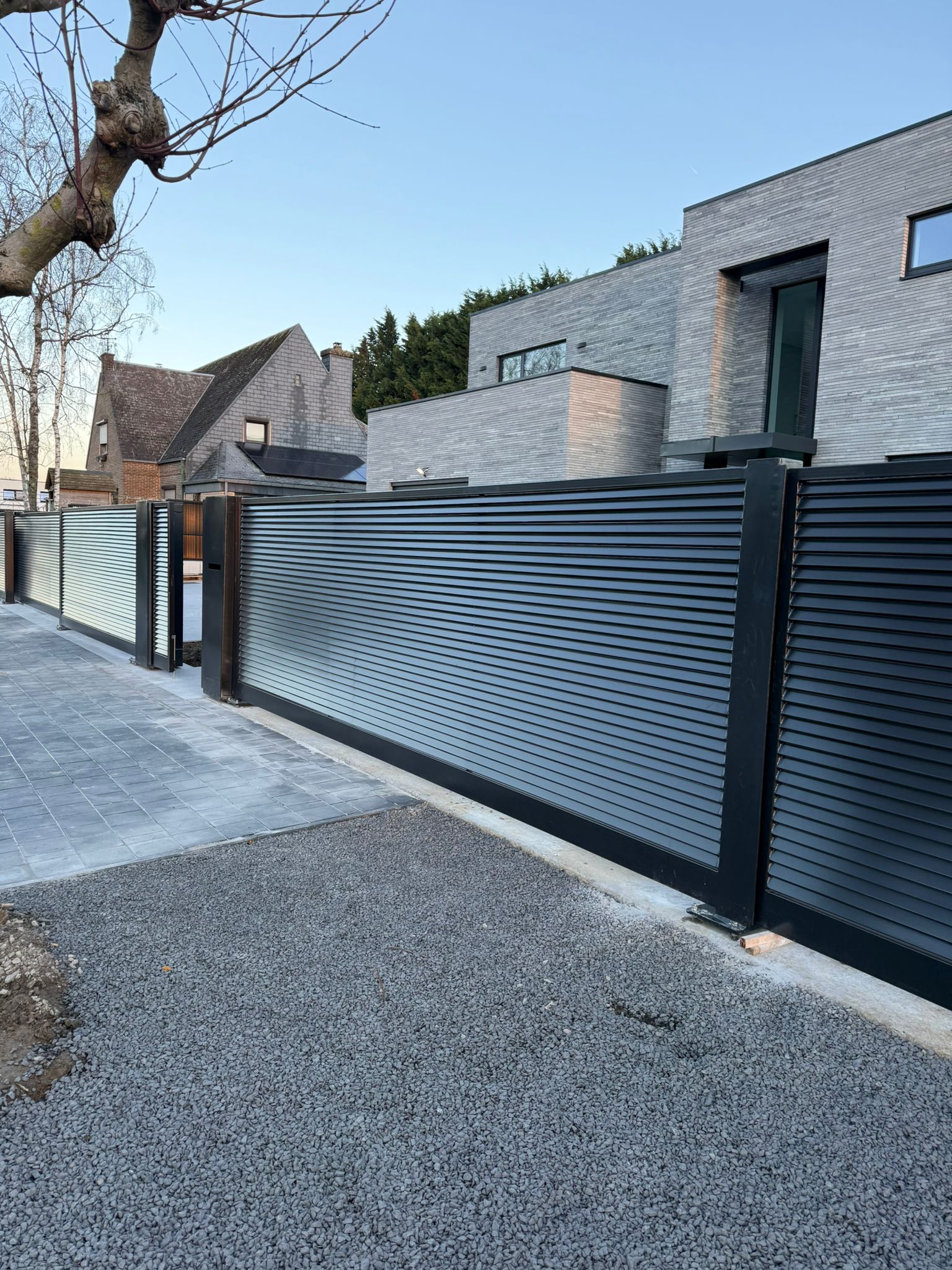 Détail d’un portail coulissant anthracite à lames horizontales et de sa clôture assortie